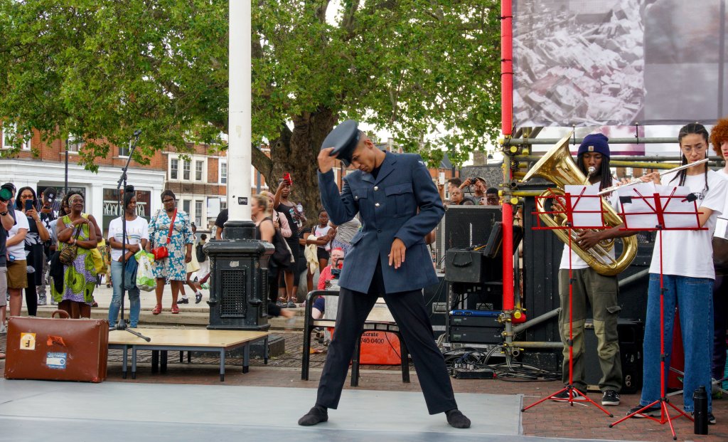 Male ballet dancer in Air Force uniform, performing outside.